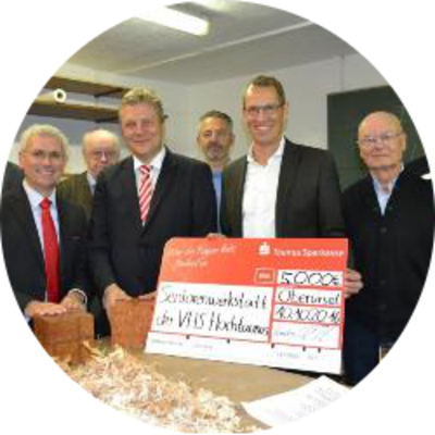 Oliver Klink, Vorstandsvorsitzender der Taunus Sparkasse (links vorne), und Landrat Ulrich Krebs (Bildmitte vorne) übereichen 5.000 Euro aus der gemeinnützigen Stiftung für die Seniorenwerkstatt in Oberursel an Carsten Koehnen (Bildmitte vorne), den Vorsitzenden der vhs Hochtaunus (Bildmitte mit Scheck).
