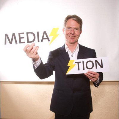Nikolaus Weitzel mit hält Karte mit dem Schriftzug Mediation hoch