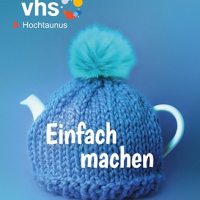 Ausschnitt des Titelbildes der Programmhefte Herbst- / Winter 2026, Teekanne mit gestrickter blauer Bommelmütze vor blauem Hintergrund