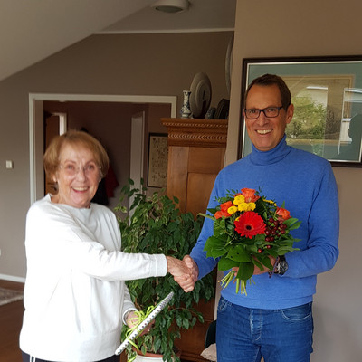 vhs Leiter Carsten Koehnen übergibt Margot Göz zur Verabschiedung einen Blumenstrauß und bedankt sich für 48 Jahre Lehrtätigkeit an der vhs Hochtaunus.
